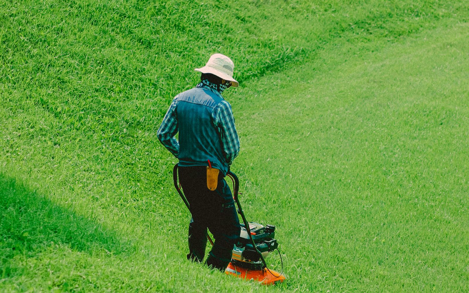 A technician mowing a large open lawn